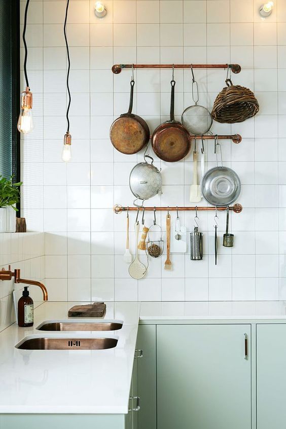 Copper Rails Organize Pots and Utensils Above a Counter