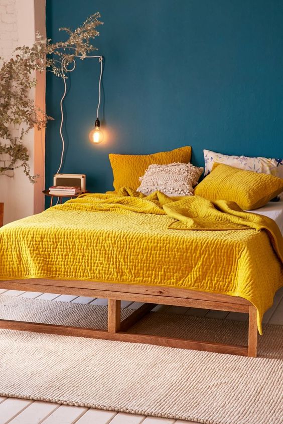 Warm Up Bold Blue Walls With a Yellow Quilt