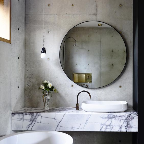 Contrast Concrete Walls with a Marble Countertop and Vessel Sink