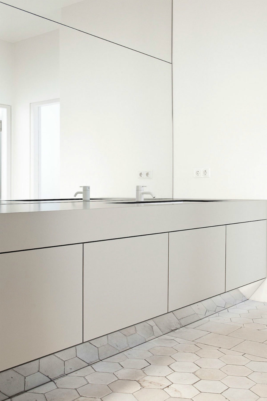 Wall-to-Wall Mirror Reflects Hexagonal Tile Floor