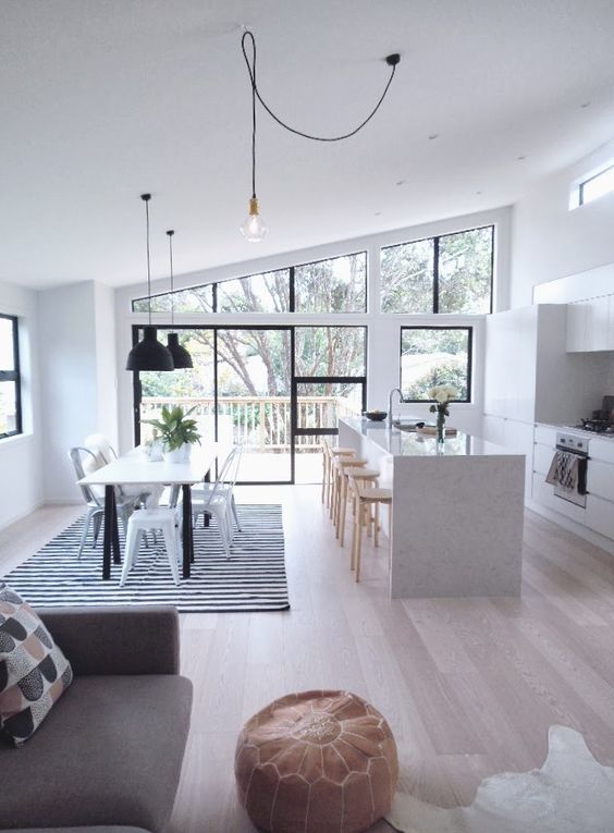 Black Pendant Lights and Striped Rug Define Dining Area