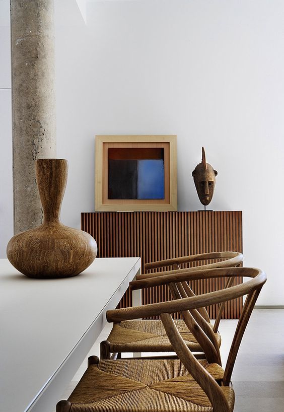 Wooden Mask Adds Sculptural Interest Above Slatted Cabinet