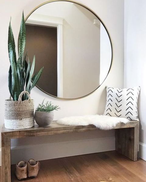 Round Gold Mirror Above Wooden Bench Adds Welcoming Warmth