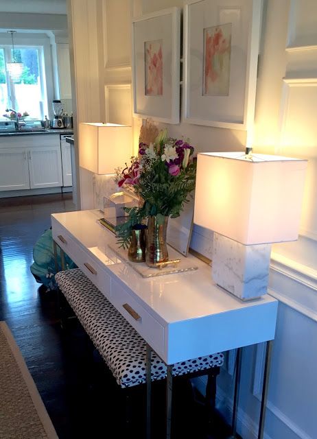 White Console Table With Dual Lamps and Floral Arrangement