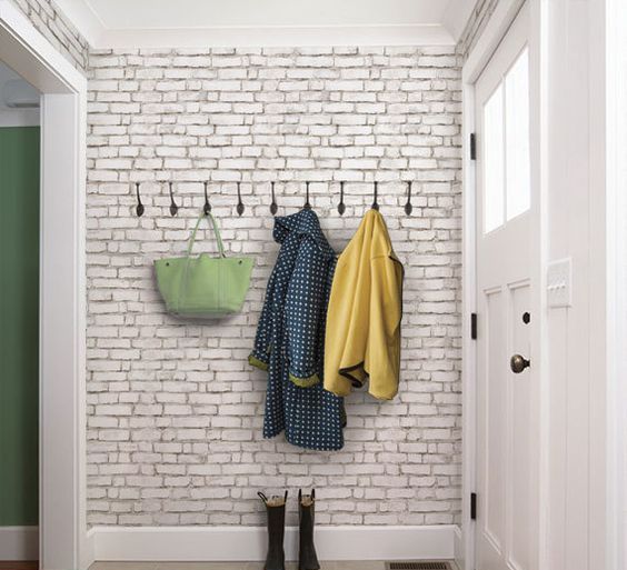 Row of Hooks for Coats and Bags on White Brick
