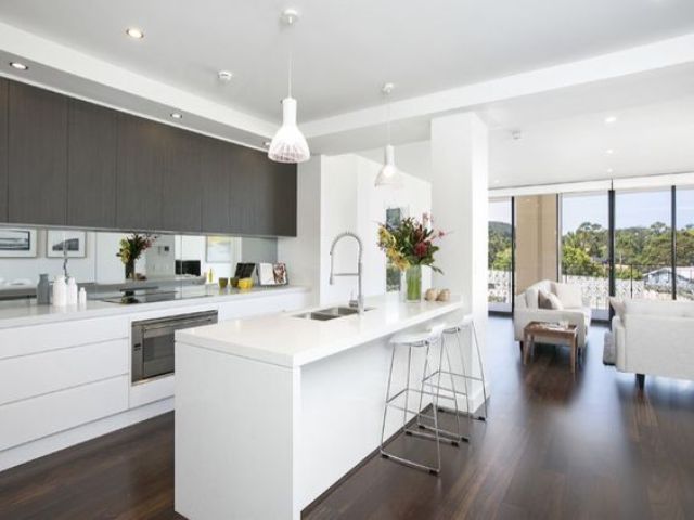 Dark Wood Grain Cabinets Reflect Light with Mirrored Backsplash