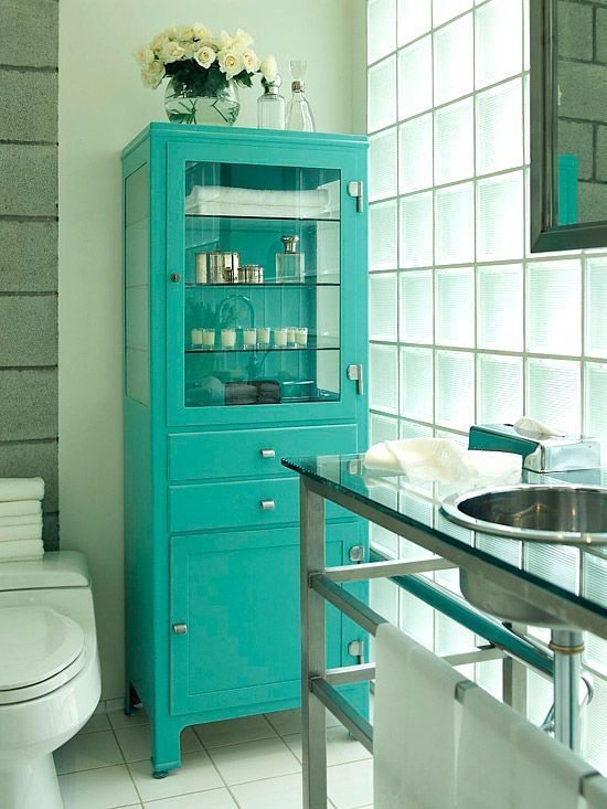 Turquoise Cabinet Displays Bathroom Essentials Behind Glass