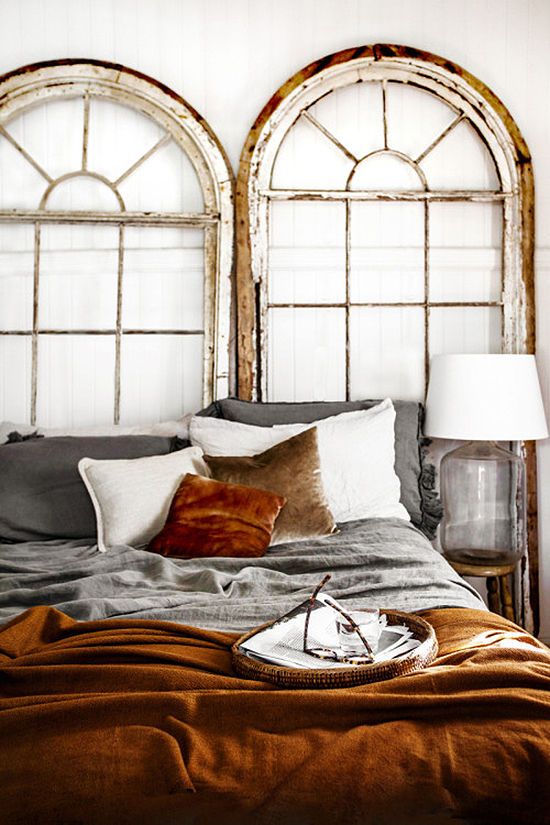 Salvaged Arched Window Panes Frame a Cozy Bed