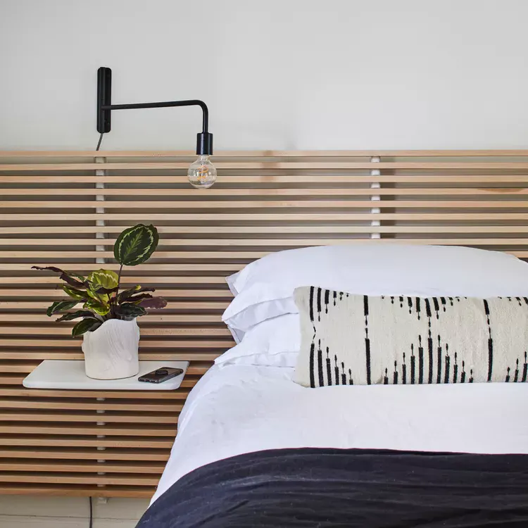 Floating White Shelf Adds a Small Surface Beside the Bed
