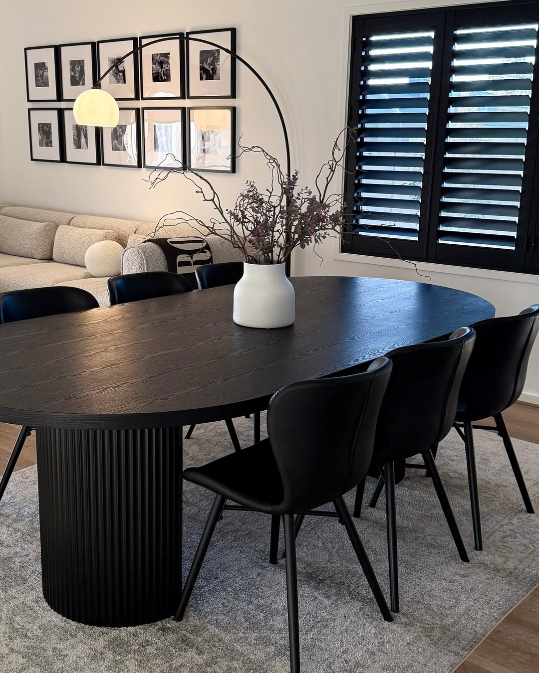 Fluted Pedestal Base Grounds a Dark Oval Dining Table