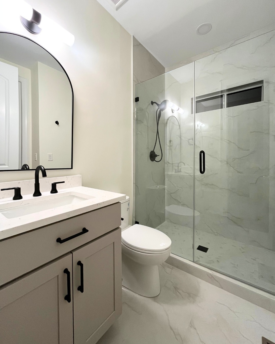 Matte Black Fixtures Ground a Light Marble Bathroom