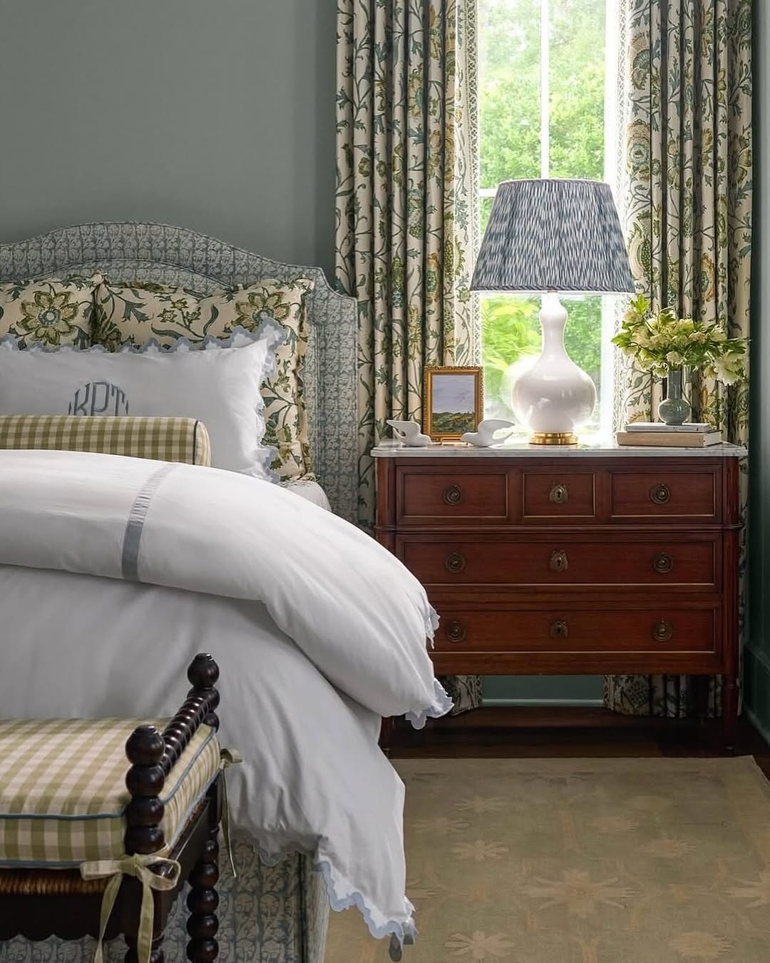 Dark Wood Nightstand With Marble Top Holds Lamp and Artwork