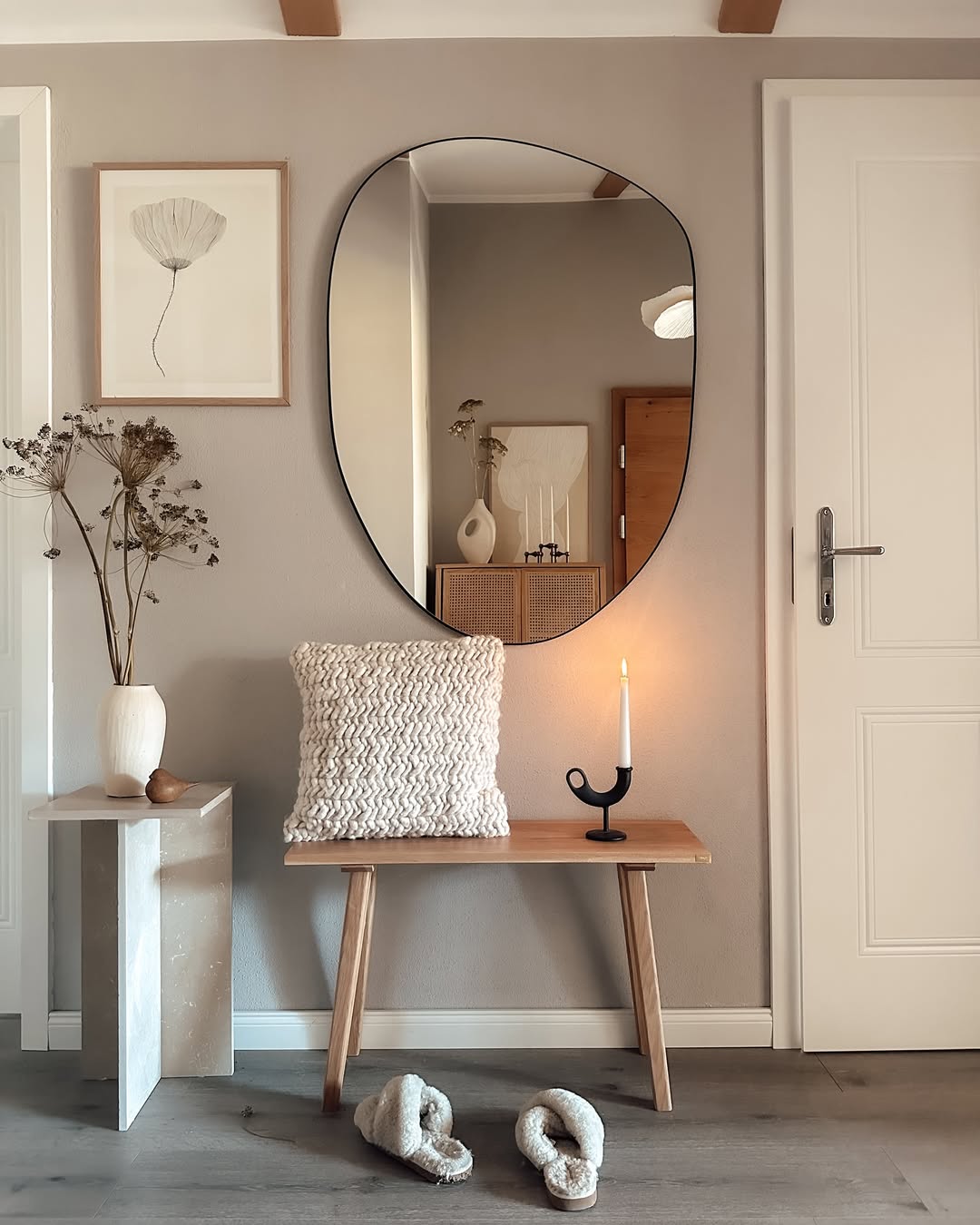 Organic Mirror Reflects Rattan Cabinet and Artwork