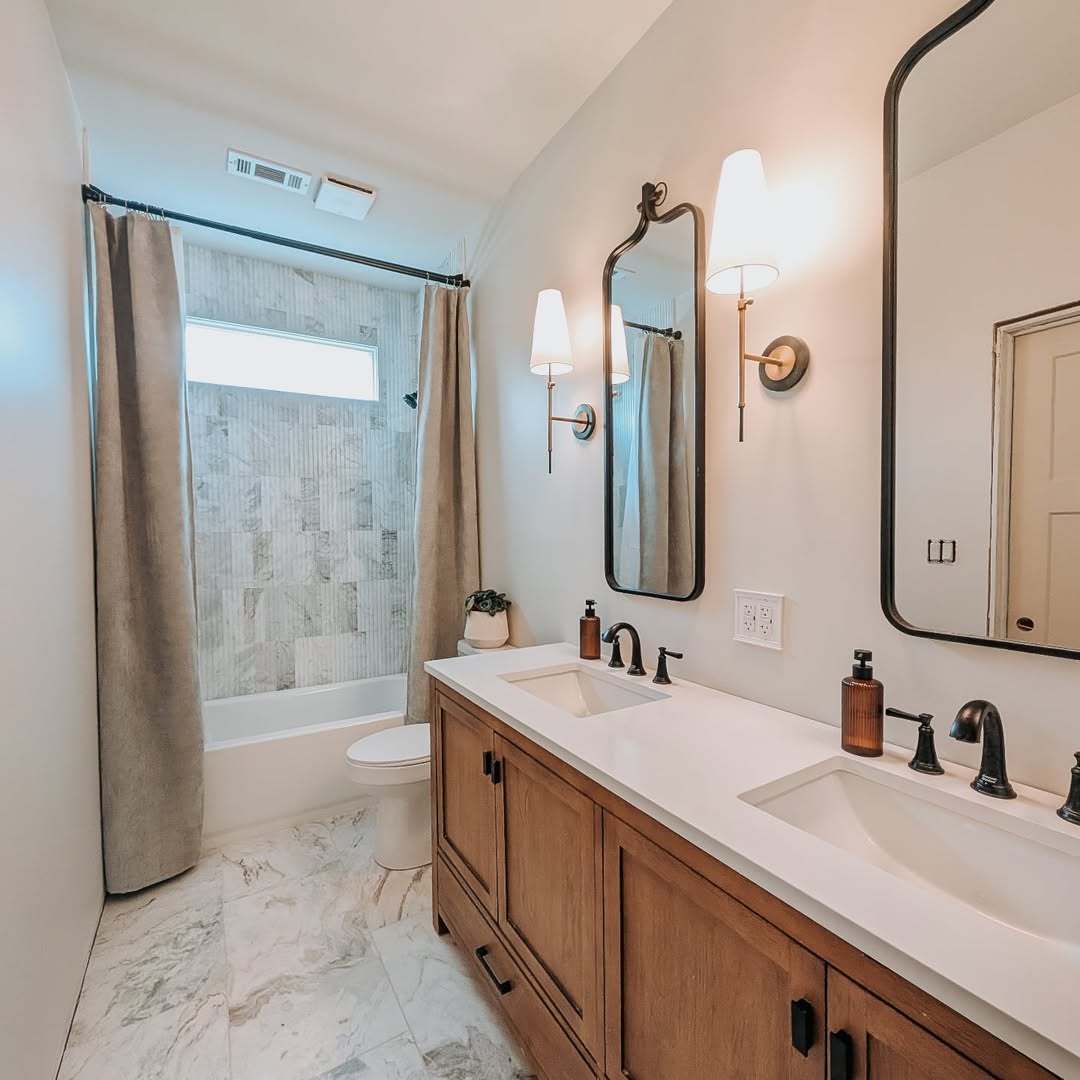 Tall, Narrow Mirrors Frame Sconces Above a Double Vanity