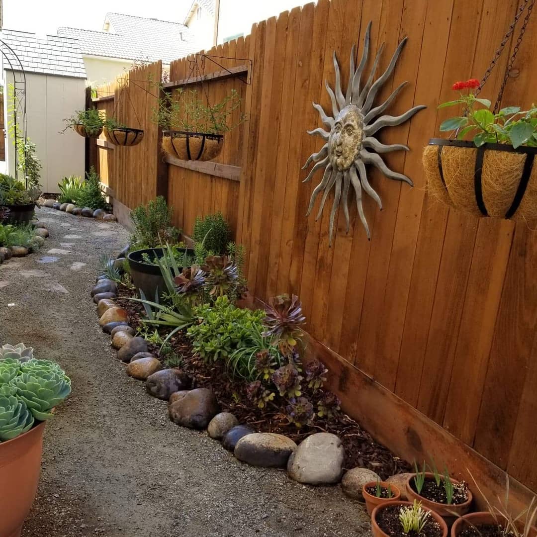 Hanging Coconut Planters Add Natural Texture To A Wooden Fence