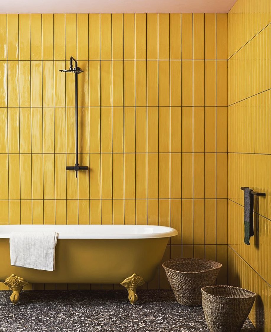 Tall Vertical Tiles Create a Striking Yellow Shower Wall