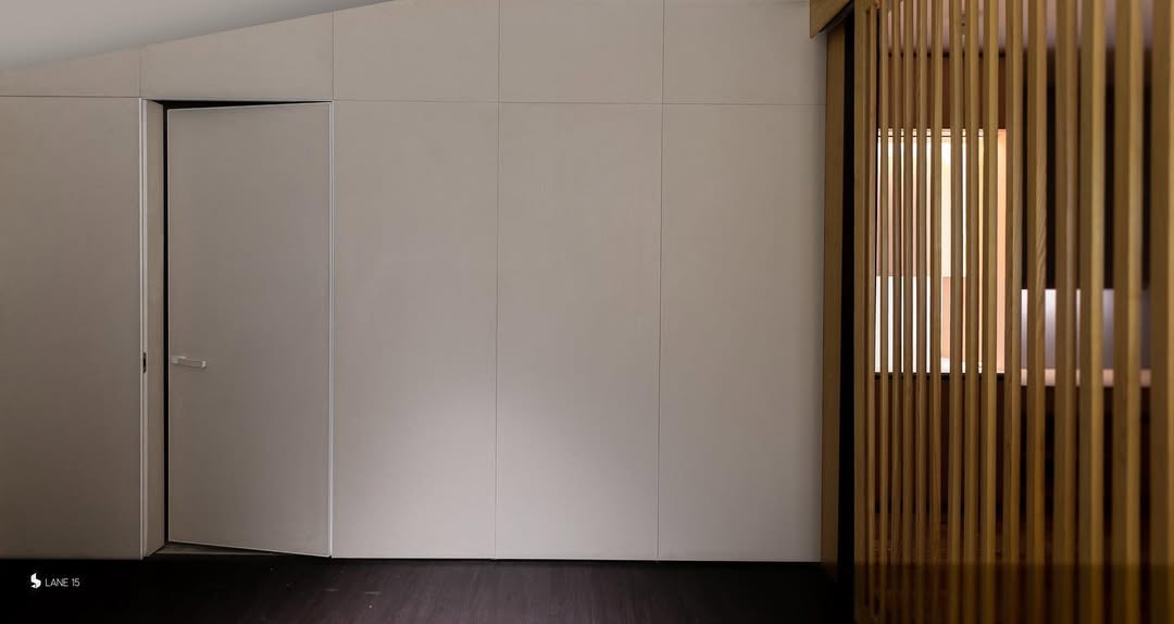 Flush White Door Blends Into Wall Panels