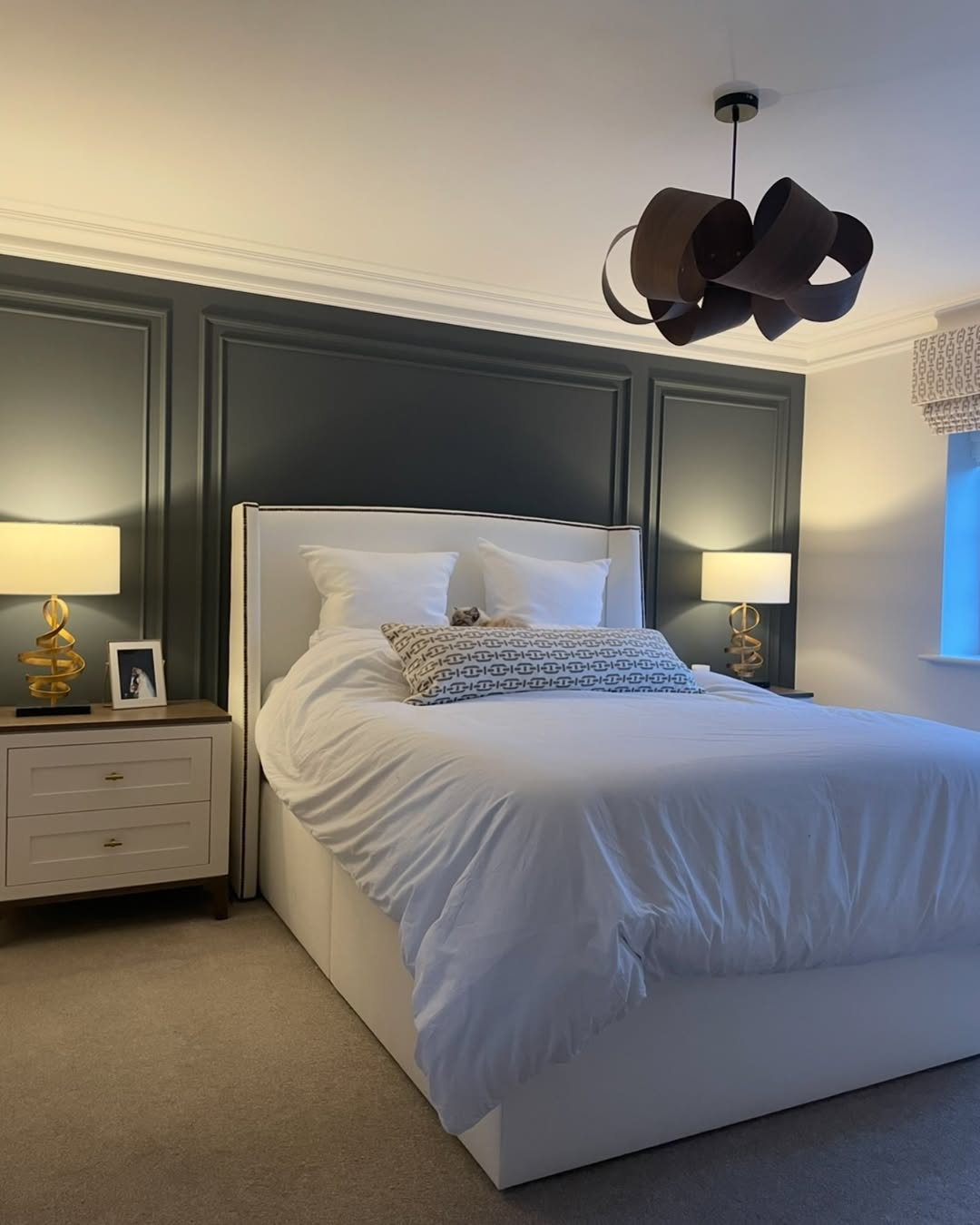 Dark Paneled Wall Creates a Dramatic Backdrop for the Bed