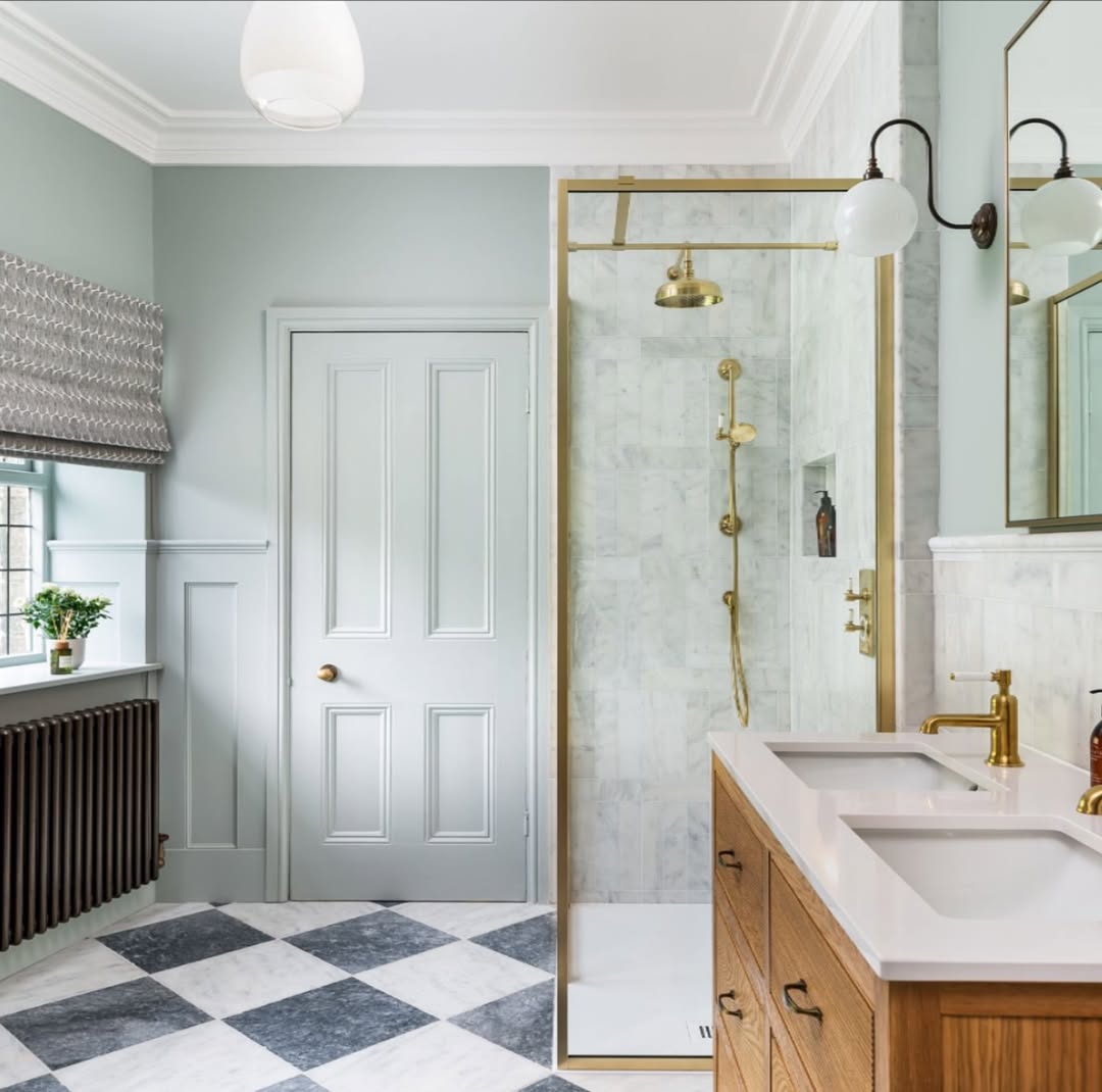Brass Shower Enclosure Adds Warmth to Marble Walls