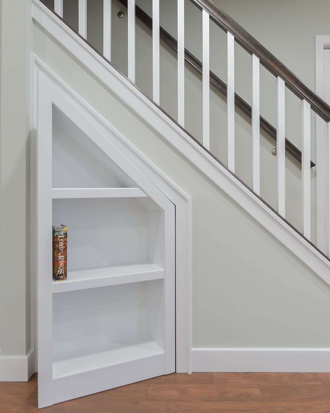 Hidden Bookshelf Door Tucks Away Under the Stairs