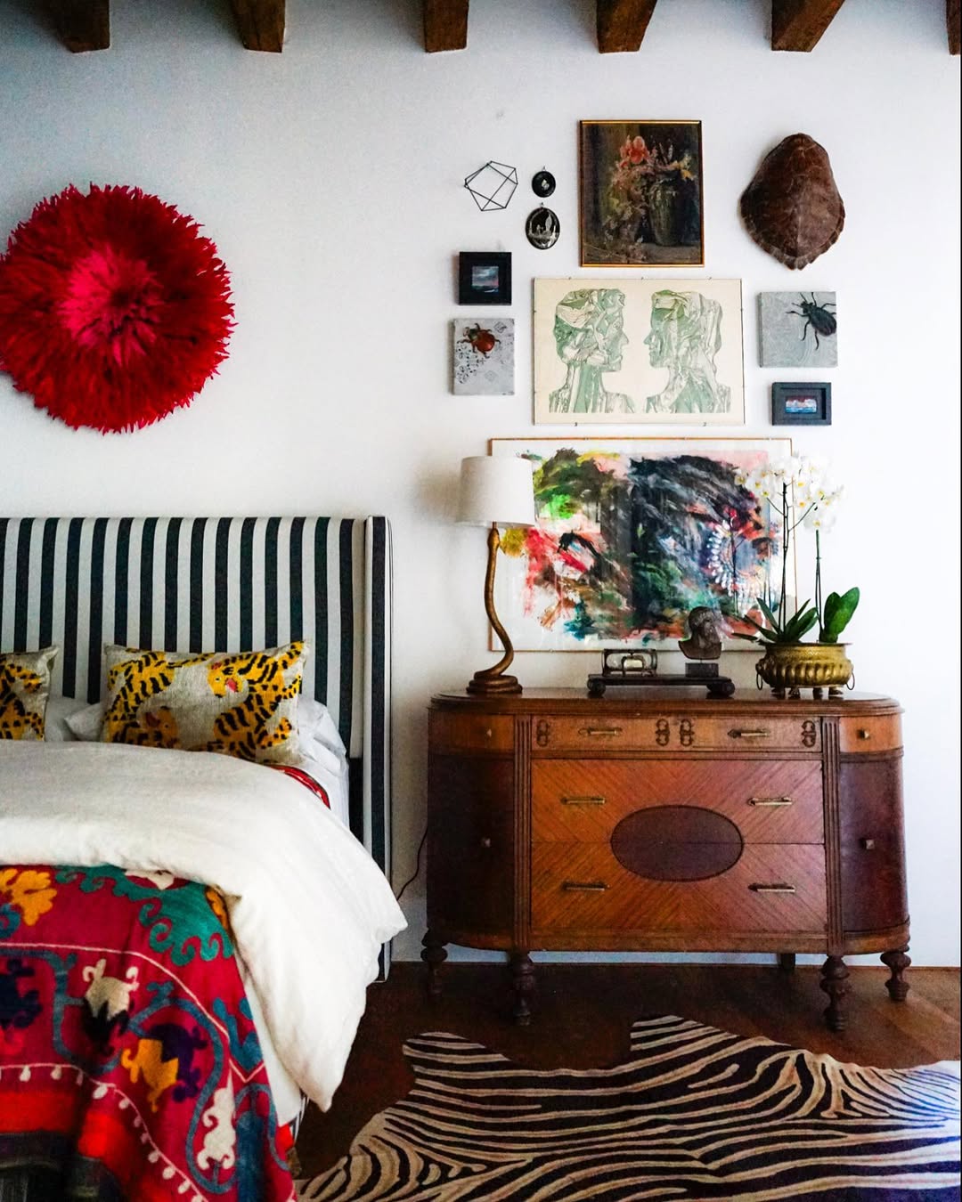Layered Wall Art Above a Dresser Creates an Eclectic Gallery