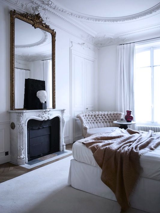 Anchor the Fireplace with a Tall Ornate Mirror and Sculptural Accents