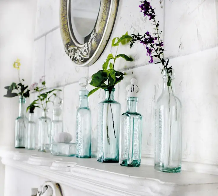 Aqua Glass Bottles Hold Single Stems and Greenery