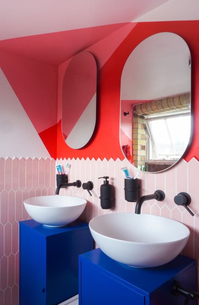Bold Blue Cabinets Beneath White Pedestal Sinks