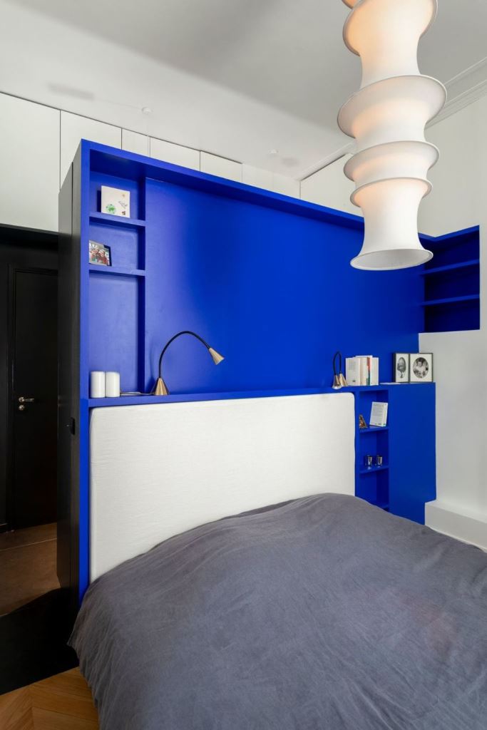 Built-in Cobalt Blue Shelving Frames the Bedside Area