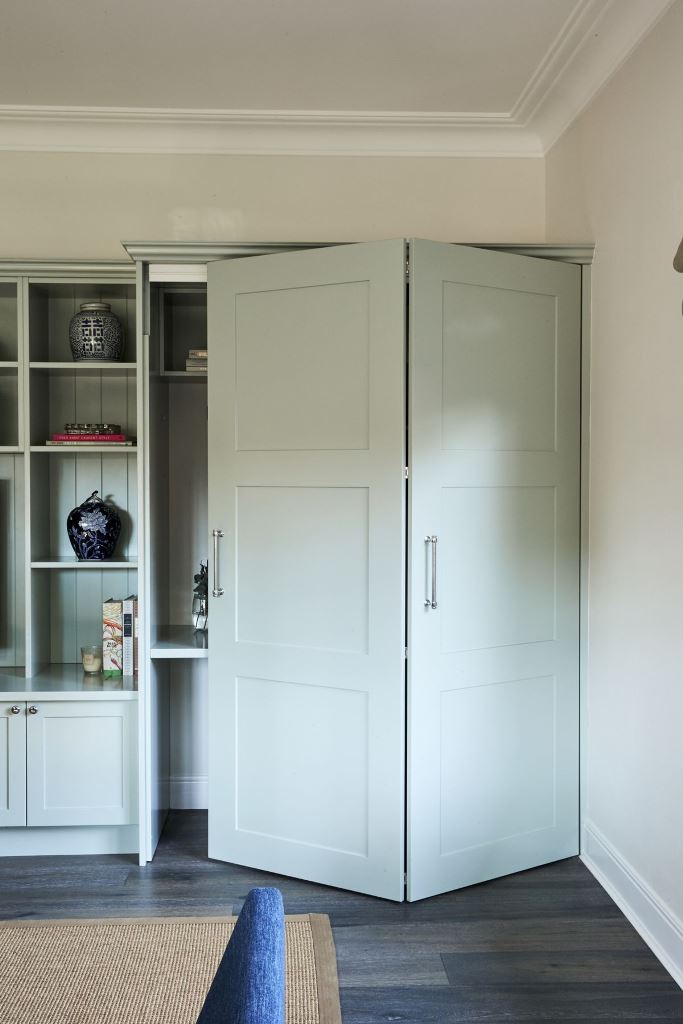 Light Blue Bi-Fold Doors Conceal Built-In Shelving