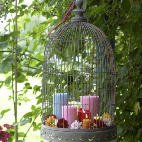 Bird Cage Filled With Candles and Flowers